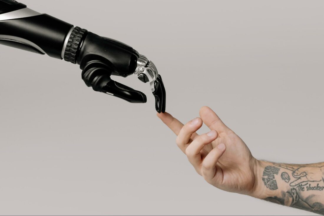 the human hand is in contact with the AI robot's hand.